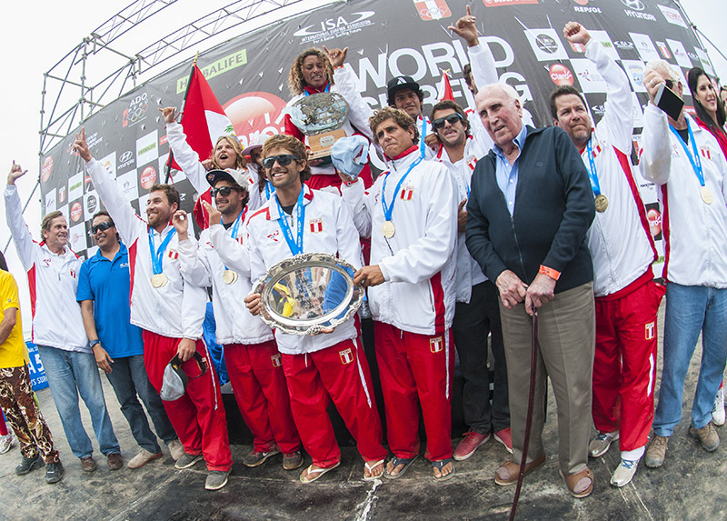 Team Peru, the Claro ISA 50th Anniversary World Surfing Games Team Champions, holding the Fernando Aguerre World Team Trophy, joined by the first ISA President in 1964, Eduardo Arena. Photo: ISA/Rommel Gonzales
